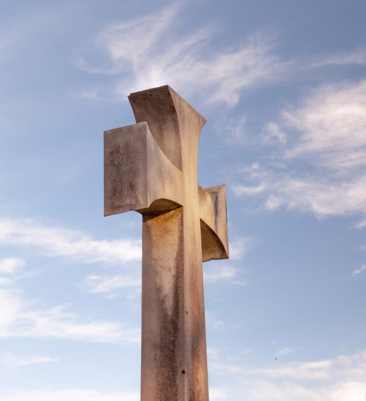 Carved granite cross monument against an open sky